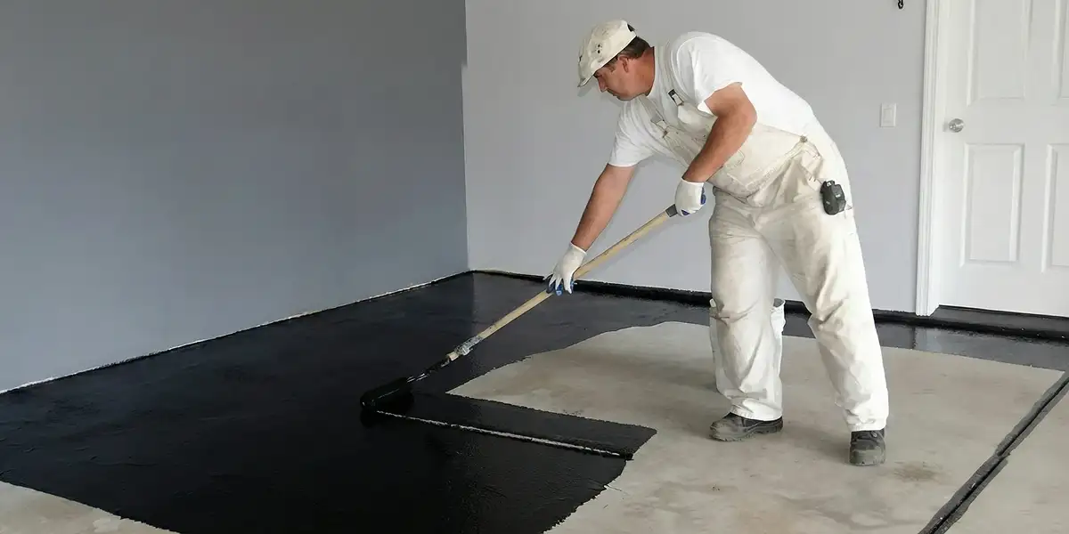 basement waterproofing professional applying waterproof coating to protect a basement floor in Tampa, FL